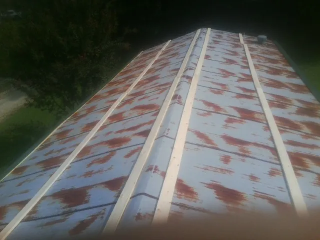 Rusted metal roof panels with new wood purlins before replacement — Storm Damage Roof Repair in Dellroy by Roofing Brothers