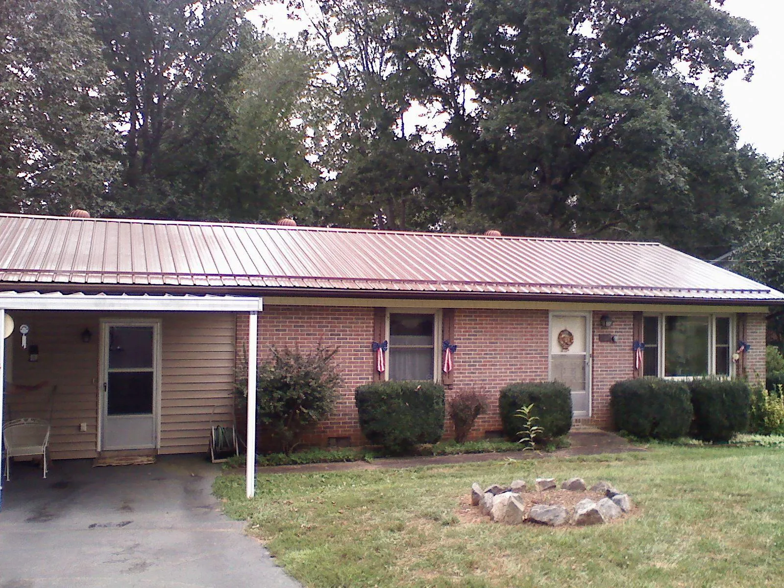 Bronze metal roof and carport on a brick ranch home — Roof Repair work by our crew in Dellroy